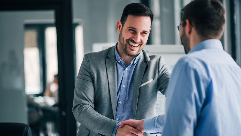 Portrait of cheerful global management professional handshake with another business executive